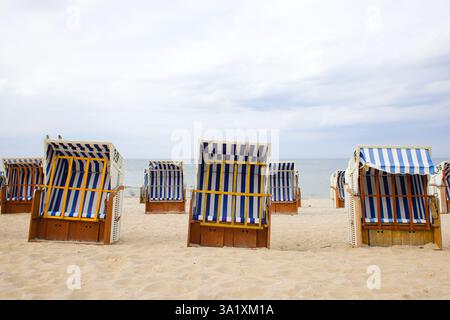 Ein eindrucksvoller Blick auf den Strand von Kolobrzeg zeigt alte Strandkörbe aus Holz und Korb mit weiß-blau gestreiftem Stoff, die auf dem Sand stehen Stockfoto
