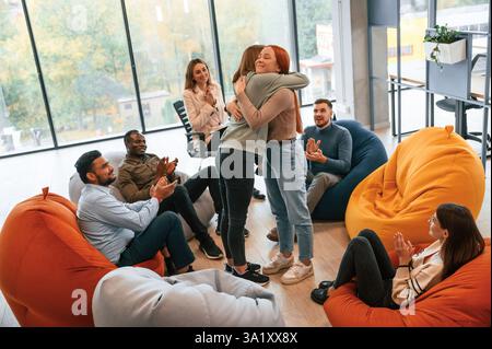 Frauen begrüßen und unterstützen einander. Eine Gruppe von Menschen trifft sich zusammen mit einer Therapie. Stockfoto