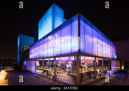 Nächtliches Treffen auf der Dachterrasse des Southbank Centre's National Theatre, London. Die Leute genießen Drinks und Gespräche. Stockfoto