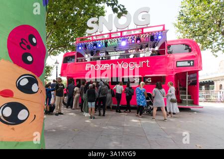 Snog Frozen Jogurt Bus, wahrscheinlich ein umgebauter Londoner Doppeldecker, der Kunden nahe der Themse bedient. Warteschlange für Personen. Stockfoto