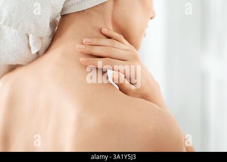 Junge unkenntlich Dame in Handtuch Feuchtigkeit ihre Haut gewickelt Stockfoto
