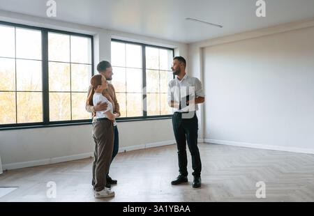 Leerer Raum. Der Makler zeigt einem jungen Paar eine Wohnung. Stockfoto