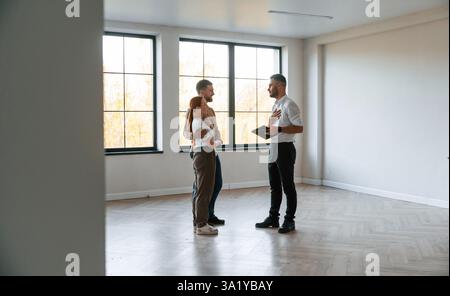 Leerer Raum. Der Makler zeigt einem jungen Paar eine Wohnung. Stockfoto