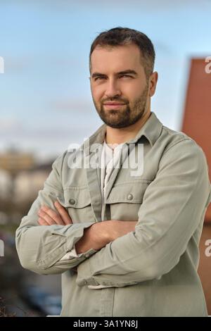 Porträt eines jungen glücklichen Kausalmannes draußen, der in die Kamera schaut. Stockfoto