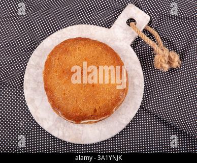 Dessert aus gebackenem Brotteig, eingeweicht in Zuckersirup, serviert mit frischer Sahne, ekmek kadayifi, traditionellem ramadan und Festessen Dessert. Stockfoto