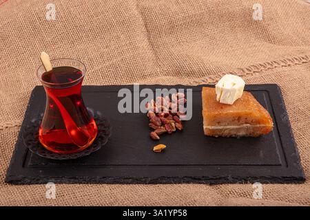 Dessert aus gebackenem Brotteig, eingeweicht in Zuckersirup, serviert mit frischer Sahne, ekmek kadayifi, traditionellem ramadan und Festessen Dessert. Stockfoto