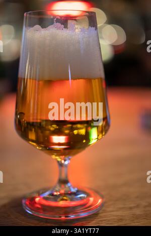 Goldenes Bier in elegantem Glas auf Holztisch Stockfoto