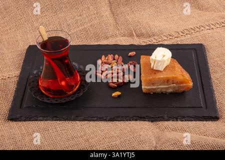 Dessert aus gebackenem Brotteig, eingeweicht in Zuckersirup, serviert mit frischer Sahne, ekmek kadayifi, traditionellem ramadan und Festessen Dessert. Stockfoto