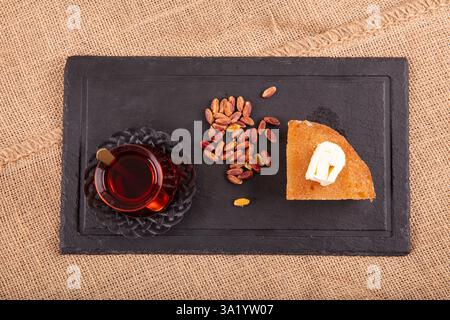 Dessert aus gebackenem Brotteig, eingeweicht in Zuckersirup, serviert mit frischer Sahne, ekmek kadayifi, traditionellem ramadan und Festessen Dessert. Stockfoto