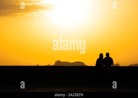 Liebe Paare. Sonnenuntergang und Liebhaber. Frau und Mann vor dem Hintergrund des Sonnenuntergangs. Orangefarbener Himmel und Sonne. Stockfoto