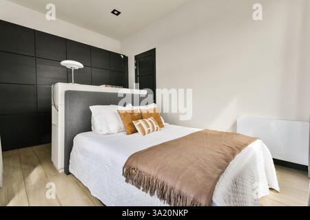 Ein schickes, modernes Schlafzimmer mit klarem Design, warmen Tönen und stilvollen Möbeln, die eine ruhige Atmosphäre zum Entspannen schaffen. Stockfoto