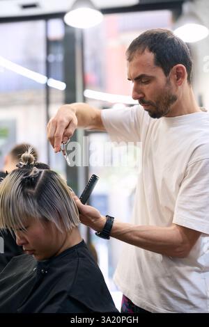 Friseur, der Haare einer jungen Frau im Salon schneidet Stockfoto