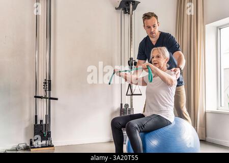 Seniorin mit physiotherapeutischer Unterstützung bei der Rehabilitationstherapie. Stockfoto