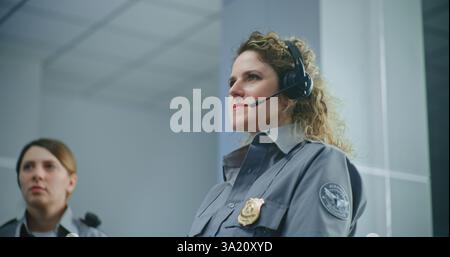 Briefing des Flughafensicherheitspersonals: Nahaufnahme der weiblichen TSA-Offizierin in Uniform mit Headset, Hören der Anweisungen während der Planungssitzung. Arbeiten Sie bei der Transportation Security Administration. Stockfoto