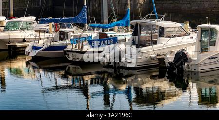 Vertäute Vergnügungsboote neben dem Quay in Sutton Harbour mit Reflections, Plymouth, Devon, England. Stockfoto
