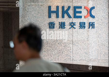 Hongkong, China. August 2024. Ein Mann läuft am Gebäude der Börse von Hongkong (HKEX) und dem Logo in Hongkong vorbei. (Credit Image: © Sebastian ng/SOPA images via ZUMA Press Wire) NUR REDAKTIONELLE VERWENDUNG! Nicht für kommerzielle ZWECKE! Stockfoto
