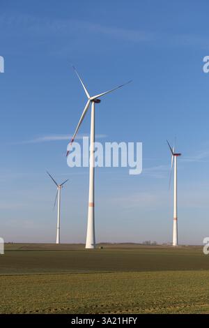 Drei hohe Windräder säumen ein weites Feld unter klarem blauem Himmel, Solarpark bei Ulm, Schwäbische Alb, Baden-Württemberg, Deutschland, Europa Stockfoto