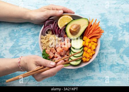 Poke Bowl Lachs mit Quinoa und Gemüse, gesunde Ernährung, Draufsicht Stockfoto