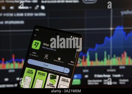 Dhaka, Bangladesch 08. März 2025: Installationsbildschirm der Wise App auf einem Smartphone und die Finanzmarktkarte im Hintergrund Stockfoto