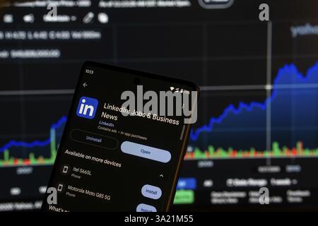 Dhaka, Bangladesch 08. März 2025: Installationsbildschirm für Jobs und Business-Apps auf einem Smartphone und die Finanzmarktkarte im Hintergrund Stockfoto