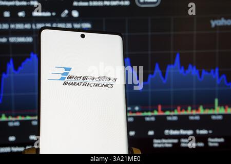 Dhaka, Bangladesch 08. März 2025: Bildschirm des Firmenlogos von Bharat Electronics auf einem Smartphone und der Finanzmarktplan im Hintergrund Stockfoto