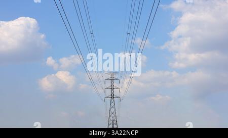 Hochspannungslampenpfosten auf einem Hintergrund von Himmel und Wolken, Stahlbetonsäule mit Hochspannungsdrähten gegen einen klaren blauen Himmel. Übertragung von Stockfoto
