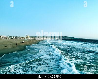 Abendansicht von Wellen, die entlang der sandigen Küste von Manhattan Beach, Kalifornien, USA brechen Stockfoto