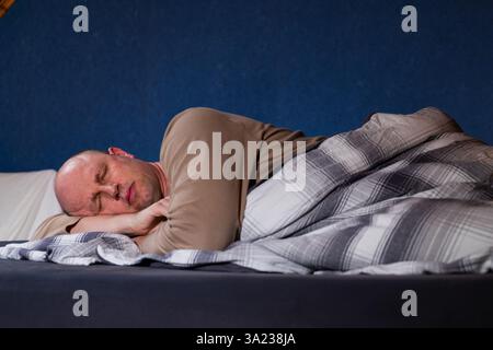 Der Mann im Bett schläft. Stockfoto