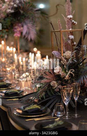Eleganter Tisch mit Kerzenlicht und Blumendekor Stockfoto