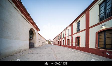 Sevilla, Spanien, 26. Juli 2022, Ein beschaulicher Weg, der von historischen Gebäuden gesäumt ist, führt zum Eingang des CAAC in Sevilla, der architektonische Highlights bietet Stockfoto