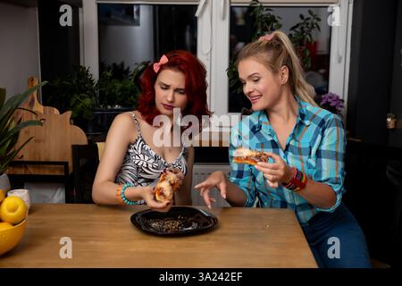 Zwei Freunde genießen gemeinsam köstliche Pizza in gemütlicher Küche Stockfoto