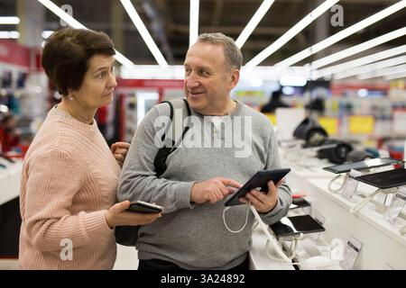 Seniorenpaar, das sich im Technikgeschäft für ein Tablet entschieden hat Stockfoto