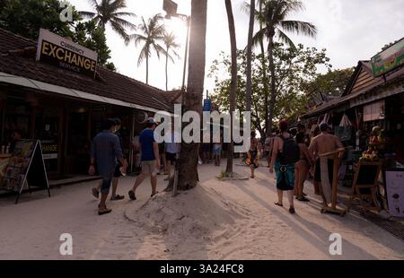 Touristen spazieren unter der warmen Nachmittagssonne auf einer Sandstraße in Railay Stockfoto