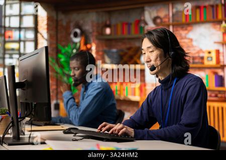 Team aus Call-Center-Agenten, die Kunden Schritt für Schritt mit dem Headset-Mikrofon beraten. Kollegen, die gemeinsam mit dem Kundensupport arbeiten und Kunden durch Problemlösungen führen Stockfoto