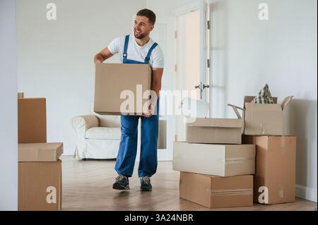 Zimmer voller Kisten. Service-Mitarbeiter wechseln. Stockfoto