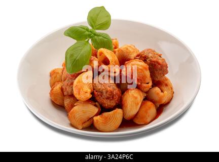 Lumaconi-Pasta mit Fleischbällchen und Tomatensauce und Basilikumblättern in einem Teller isoliert auf weiß, mit Clippingh-Pfad im Preis inbegriffen Stockfoto