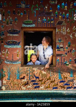 Mutter und Kind im Wat Xieng Thong, Luang Prabang, Laos. Traditionelle Kunst, Kulturfenster Stockfoto