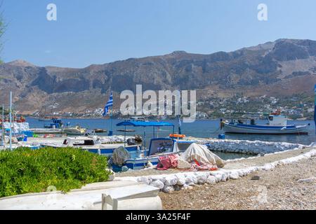 Telendos Griechenland - 29. August 2024; Küstenszene auf der Insel Telendos mit malerischen traditionellen Fischerbooten und Inselhügeln im Hintergrund; Stockfoto