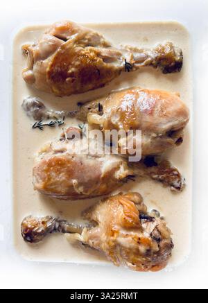 Hähnchenkeulen in cremiger Sauce mit aromatischen Kräutern. Direkt darüber. Stockfoto
