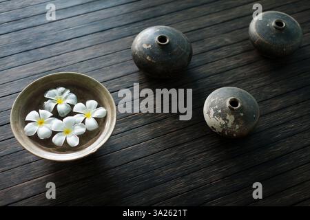 Blütenblätter der Orchideenblüte in einer Schüssel Wasser. Öllampen. Stockfoto