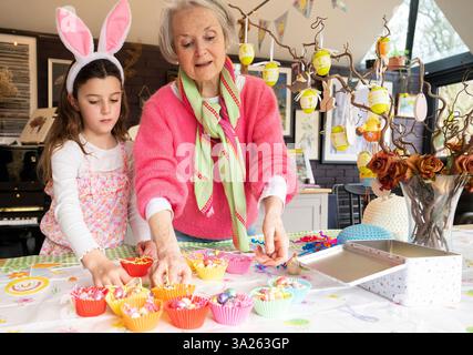 Großmutter und Enkelin machen zusammen Osterkuchen in der Küche. Stockfoto