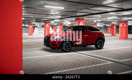 Red DS3 Crossback in Tiefgarage. Kleinwagen in leerem Parkhaus mit roten Säulen. Stockfoto