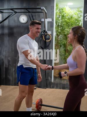 Eine dynamische Workout-Szene zeigt zwei Personen, die an einem freundlichen, motivierenden Fitnesstraining teilnehmen Stockfoto