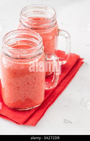 Cremiger tropischer Smoothie mit Kirsche, Banane und Ananas in einmachgläsern Stockfoto