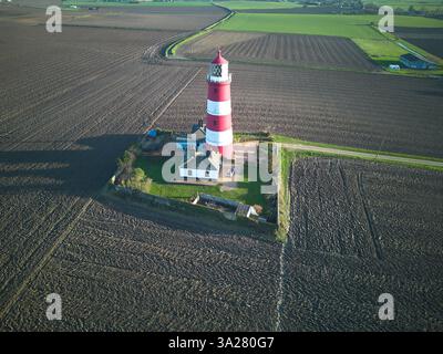 Der rot-weiß gestreifte Leuchtturm in Happisburgh an der Küste von Norfolk, Großbritannien Stockfoto