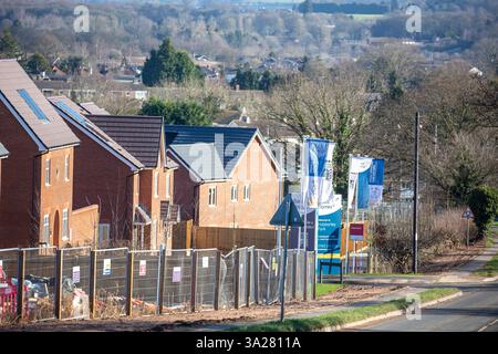 Bauzäune vor dem neuen Wohngebiet entlang einer Hauptstraße. Stockfoto
