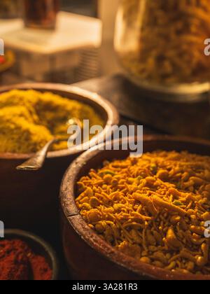 Nahaufnahme traditioneller indischer Gewürze in rustikalen Tonschalen, die die lebhaften Farben und Texturen der indischen Küche zeigen. Stockfoto