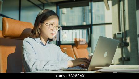 Professionelle Geschäftsfrau, die Dokumente in einem modernen Büro überprüft Stockfoto