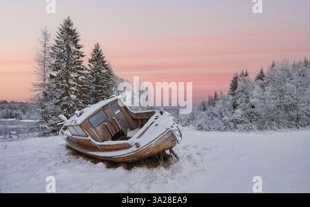 Abondendes Holzfischboot in der arktischen Winterlandschaft der Insel Senja, Nordnorwegen Stockfoto