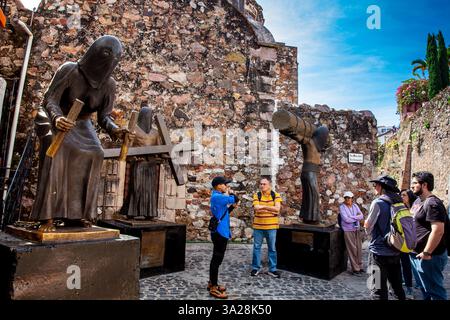 Taxco, Mexiko - 18. November 2024: Fremdenführer und Touristen am Denkmal der traditionellen Karwochenprozessionen in der wunderschönen magischen Stadt Taxco Stockfoto